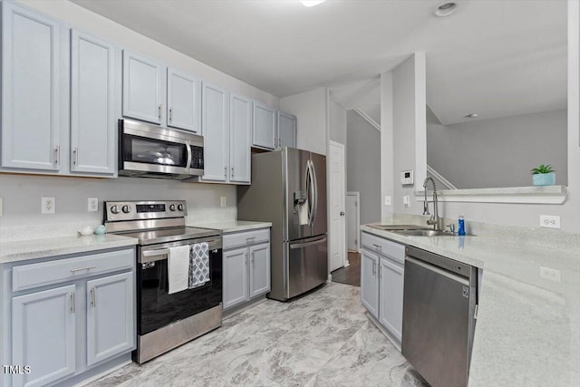 kitchen featuring gray cabinetry, sink, and stainless steel appliances