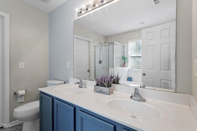 bathroom with vanity, a shower with shower door, and toilet