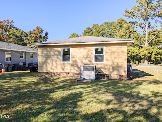 rear view of house with a yard and central AC unit