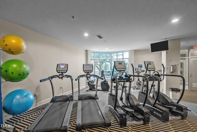 exercise room with visible vents, baseboards, a wall of windows, carpet flooring, and recessed lighting