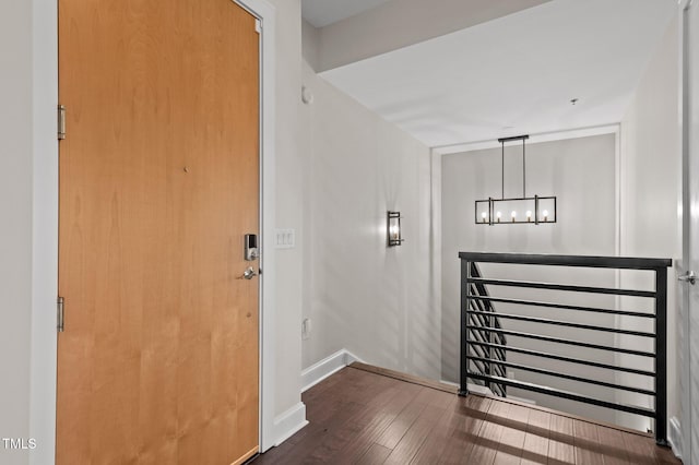 interior space featuring a chandelier, baseboards, and hardwood / wood-style flooring