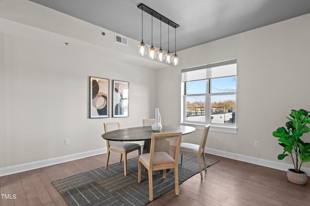 dining area featuring visible vents, baseboards, and wood finished floors