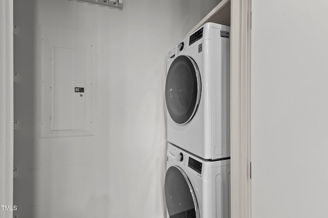 laundry area with laundry area, electric panel, and stacked washing maching and dryer