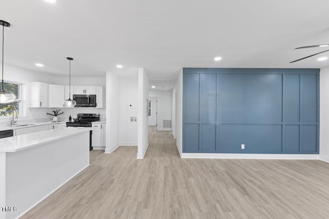 kitchen featuring stainless steel appliances, white cabinetry, sink, and pendant lighting