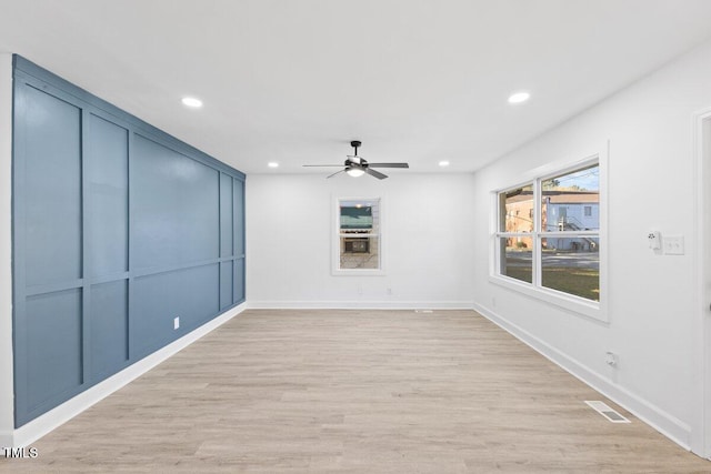 empty room with ceiling fan and light hardwood / wood-style floors