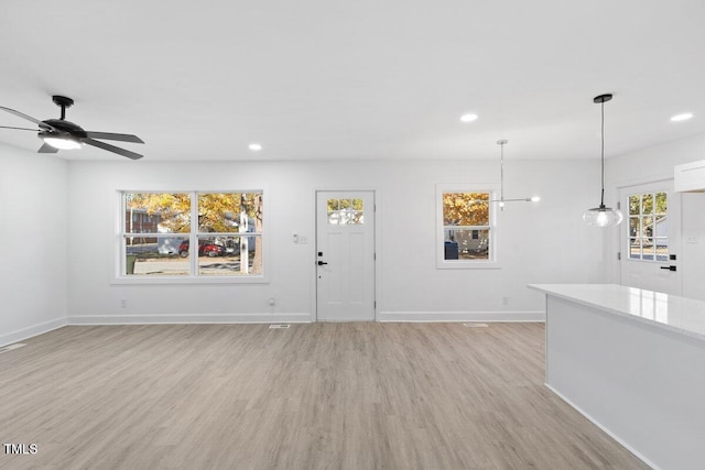 entryway with plenty of natural light, ceiling fan, and light hardwood / wood-style flooring