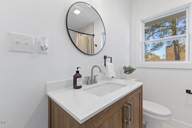 bathroom featuring vanity, toilet, and walk in shower