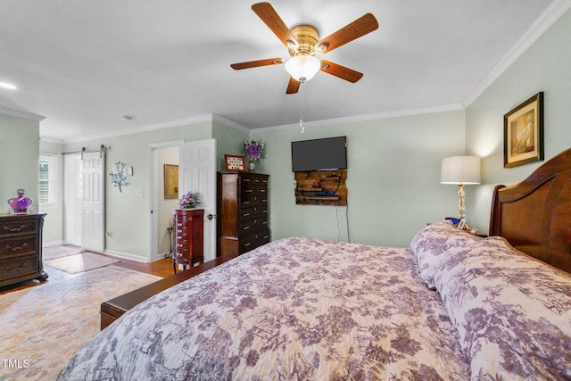 bedroom with ceiling fan, ornamental molding, and a barn door