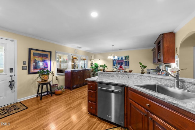 kitchen featuring light stone counters, decorative light fixtures, dishwasher, and sink