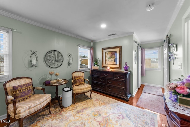 living area with ornamental molding, plenty of natural light, and light hardwood / wood-style floors