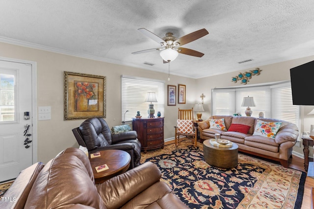 living room with hardwood / wood-style flooring, ceiling fan, crown molding, and a textured ceiling