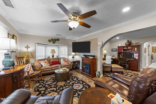 living room with hardwood / wood-style floors, ornamental molding, and a textured ceiling