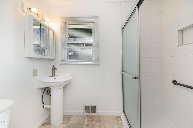 bathroom featuring toilet and an enclosed shower