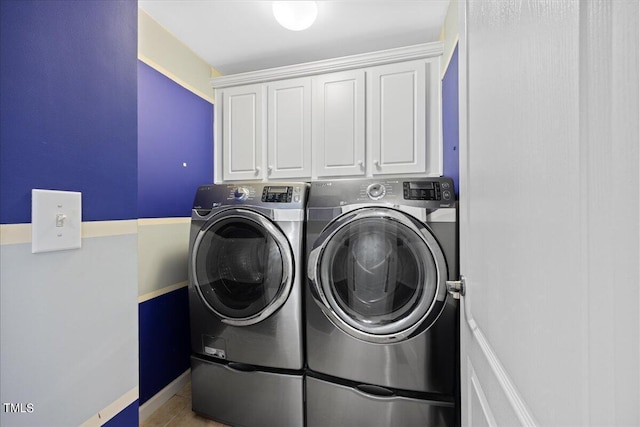 clothes washing area with cabinets and separate washer and dryer