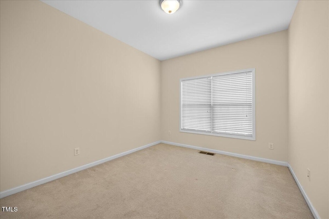 spare room featuring light colored carpet