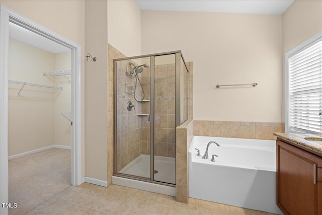 bathroom with tile patterned flooring, vanity, and separate shower and tub