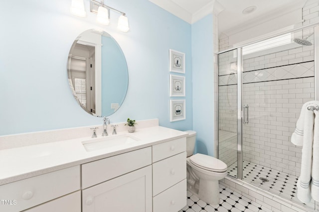 bathroom featuring ornamental molding, vanity, toilet, and a shower with shower door