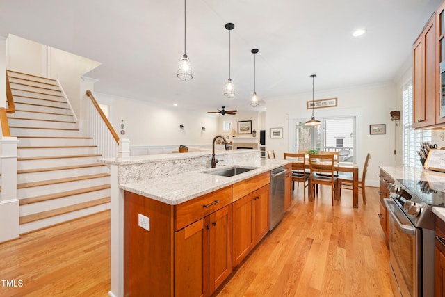 kitchen with pendant lighting, sink, a center island with sink, and appliances with stainless steel finishes