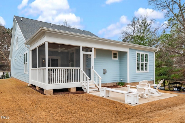 rear view of house with a lawn, a sunroom, and a patio