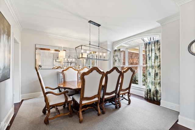 dining room with ornamental molding, baseboards, and wood finished floors