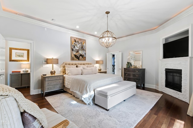 bedroom featuring a stone fireplace, baseboards, dark wood-style flooring, and ornamental molding