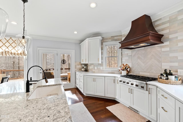 kitchen with dark wood-style floors, custom exhaust hood, crown molding, stainless steel gas cooktop, and a sink