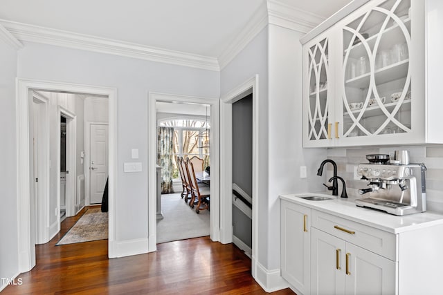 bar with crown molding, dark wood finished floors, backsplash, a sink, and baseboards