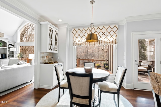 dining area featuring dark wood-style floors, plenty of natural light, baseboards, and crown molding