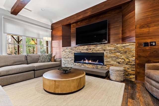 living area with a fireplace, wood finished floors, visible vents, beamed ceiling, and crown molding