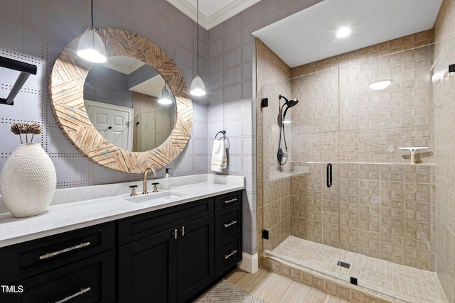 bathroom featuring ornamental molding, tile walls, a shower stall, and vanity