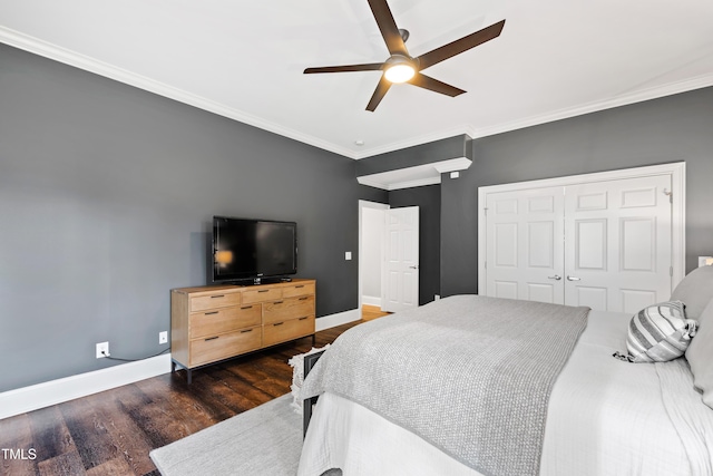 bedroom featuring a closet, crown molding, baseboards, and wood finished floors