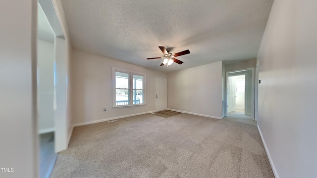 spare room with ceiling fan, light colored carpet, and a textured ceiling