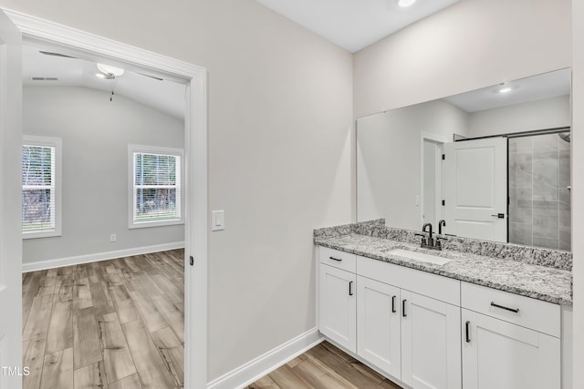 bathroom with lofted ceiling, a shower with door, wood-type flooring, and vanity