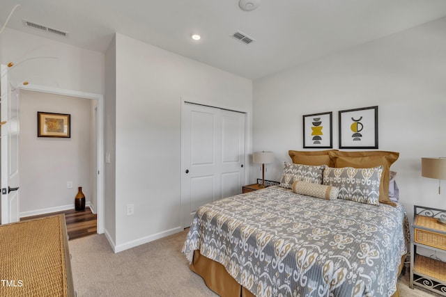 bedroom with light colored carpet and a closet