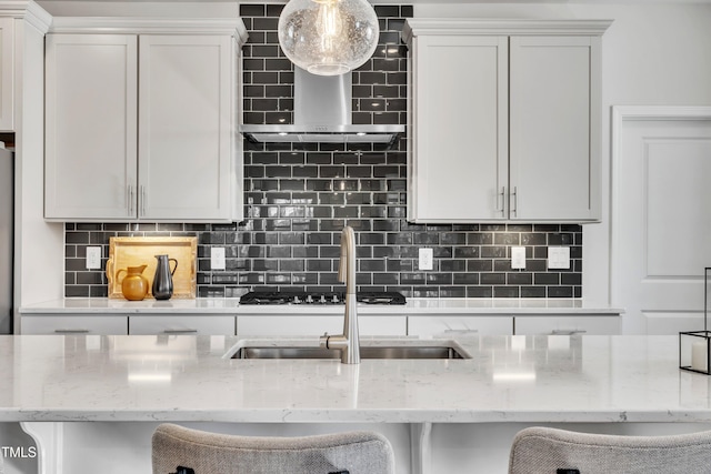 kitchen featuring white cabinetry, tasteful backsplash, light stone countertops, and a breakfast bar