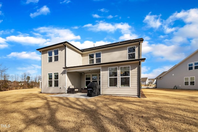 rear view of house featuring a lawn and a patio area