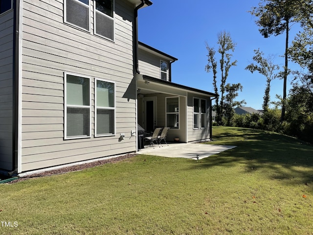 rear view of house featuring a patio and a lawn