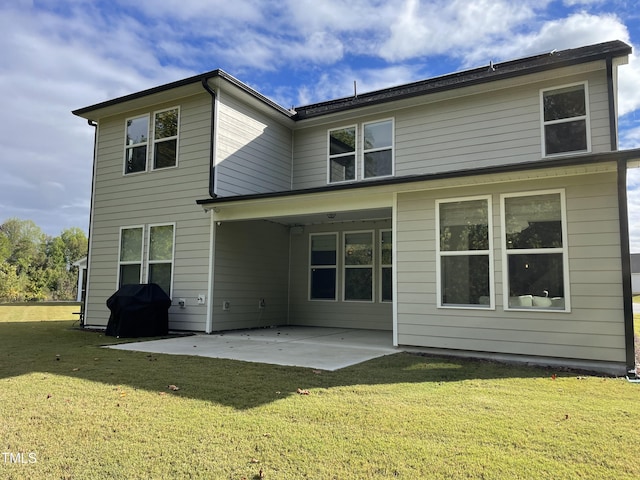 rear view of house with a patio and a lawn