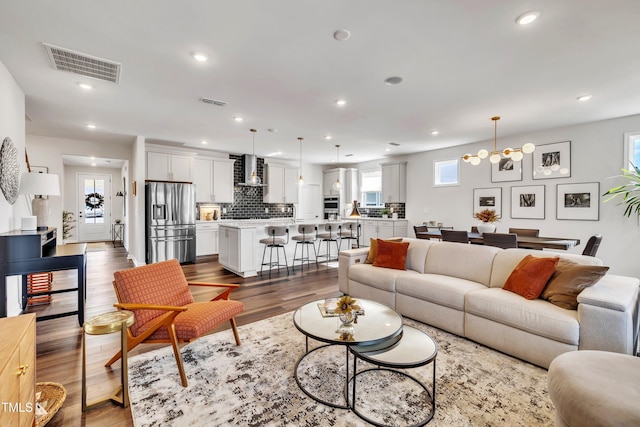 living room with an inviting chandelier and hardwood / wood-style flooring