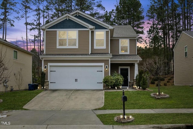 craftsman-style home featuring a garage and a lawn