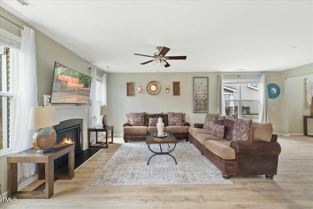 living room featuring ceiling fan and light hardwood / wood-style flooring