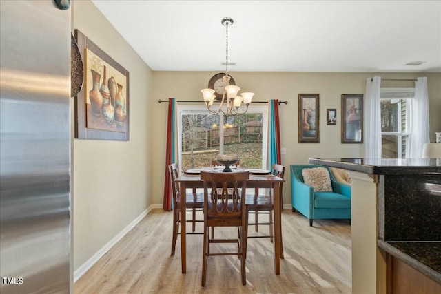 dining room with a notable chandelier and light hardwood / wood-style floors