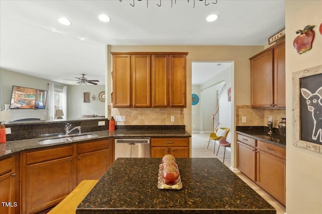 kitchen featuring dark stone countertops, sink, stainless steel dishwasher, and decorative backsplash