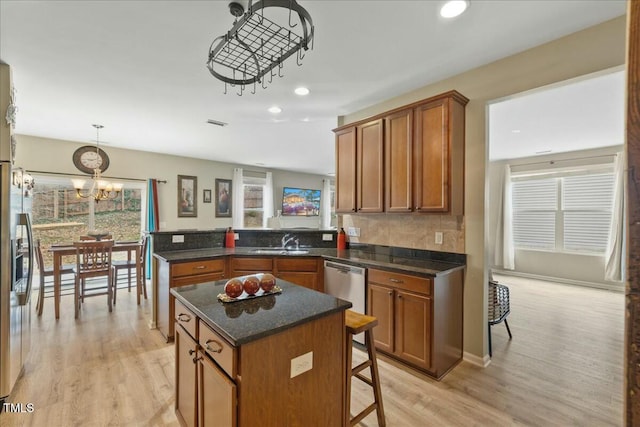 kitchen featuring sink, light hardwood / wood-style flooring, kitchen peninsula, and a kitchen island