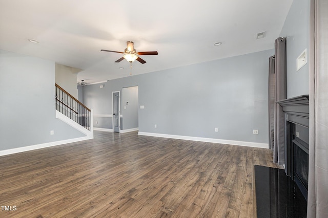 unfurnished living room with dark wood-type flooring and ceiling fan