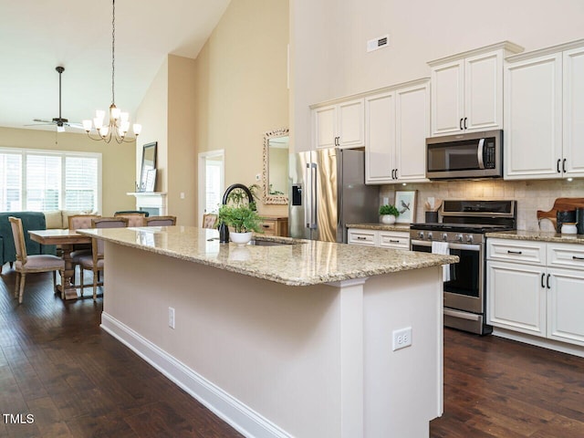 kitchen featuring sink, stainless steel appliances, a center island, dark hardwood / wood-style flooring, and decorative light fixtures