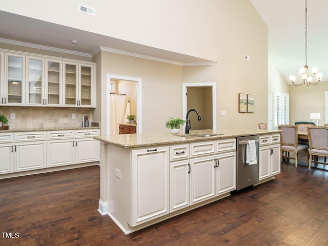 kitchen with pendant lighting, sink, dishwasher, white cabinets, and a center island with sink