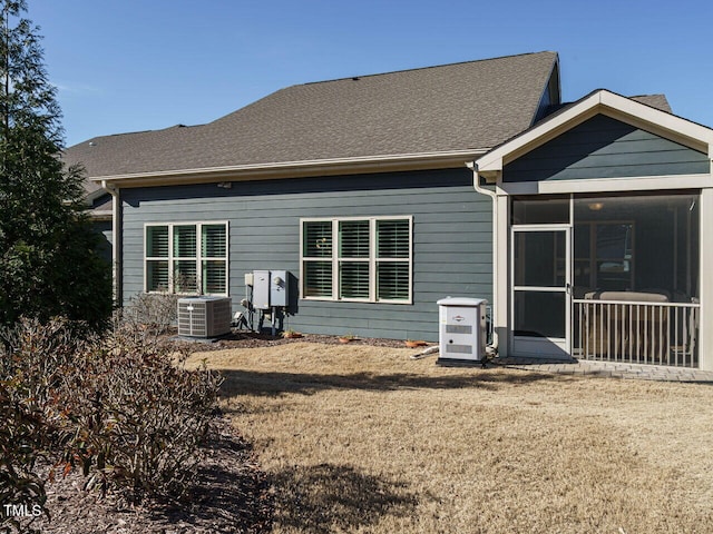 back of property featuring cooling unit, a lawn, and a sunroom