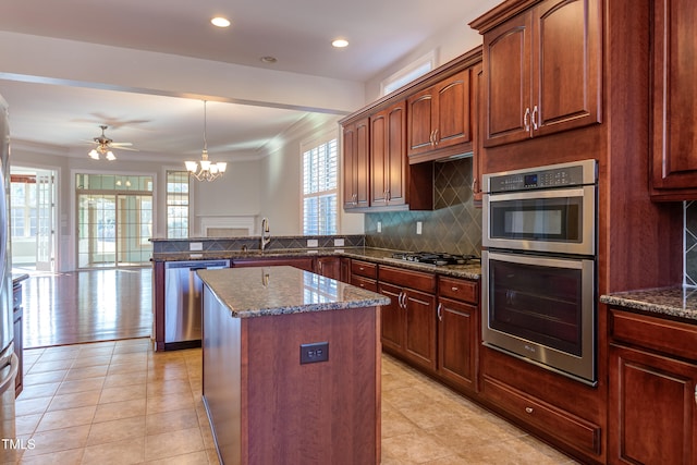 kitchen with a kitchen island, pendant lighting, sink, kitchen peninsula, and stainless steel appliances