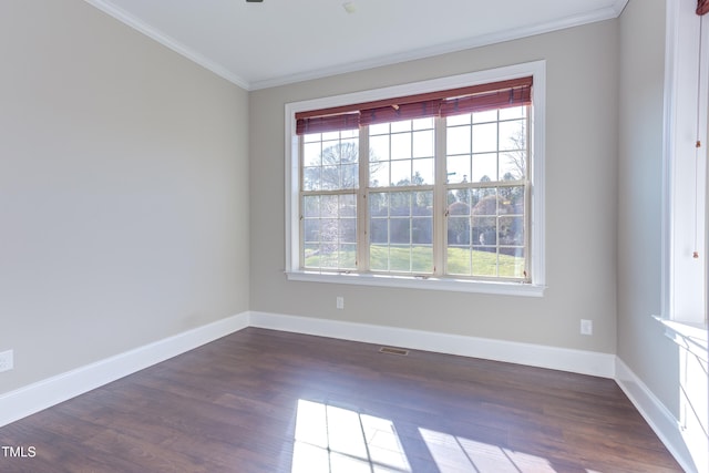 unfurnished room featuring a wealth of natural light, ornamental molding, and dark hardwood / wood-style floors